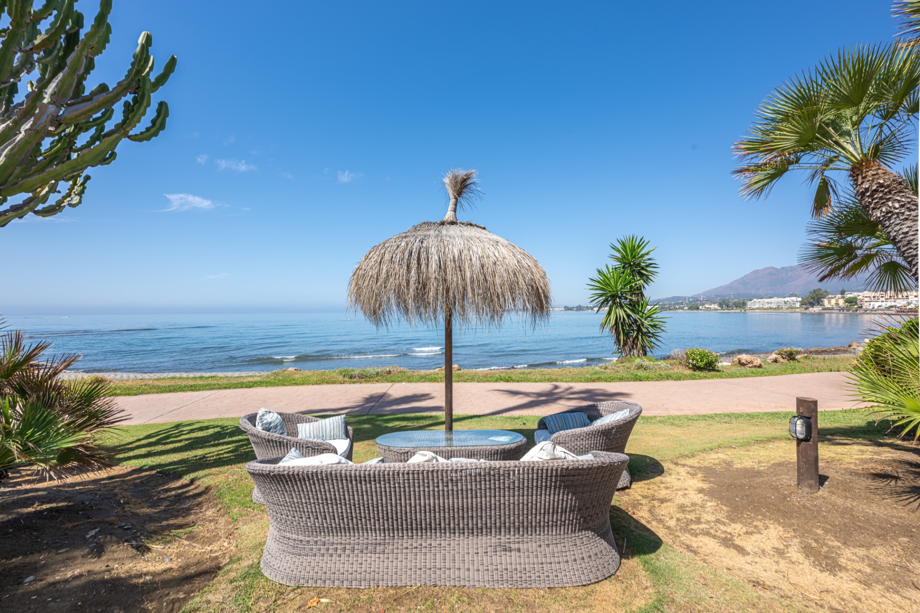 Sunlit Mediterranean terrace overlooking the sea, set for breakfast